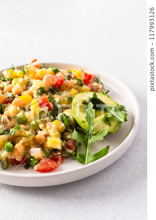 This healthy salad combines boiled millet, chickpeas, fresh vegetables, and avocado, all drizzled with olive oil for a nutritious and flavorful vegetarian meal This healthy salad combines boiled millet, chickpeas, fresh vegetables, and avocado, all drizzled with olive oil for a nutritious and flavorful vegetarian meal 117993126