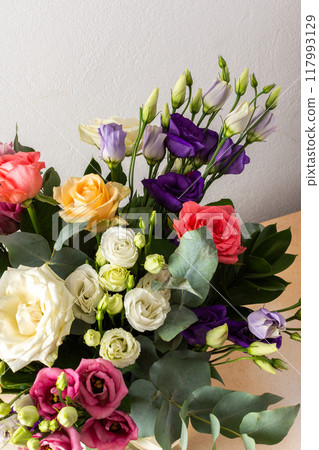 A beautiful bouquet of vibrant roses, eucalyptus, and delicate eustoma in white, pink, and purple hues, perfect for a summer anniversary or birthday celebration A beautiful bouquet of vibrant roses, eucalyptus, and delicate eustoma in white, pink, and purple hues, perfect for a summer anniversary or birthday celebration 117993129