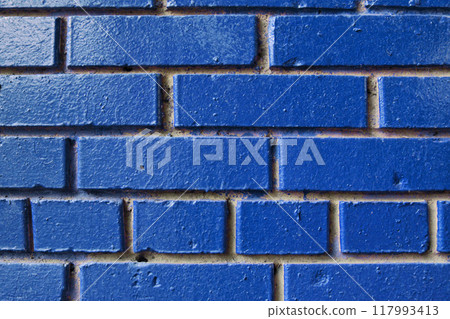 Textured blue brick wall with visible mortar lines, offering a solid and serene backdrop Textured blue brick wall with visible mortar lines, offering a solid and serene backdrop 117993413