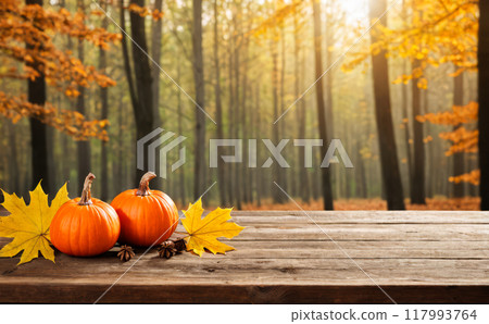 Autumn Product Presentation, Autumn pumpkins wooden table forest, seasonal fall harvest, orange gourds maple leaves, tranquil woodland backdrop, festive Thanksgiving decoration 117993764