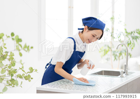 一位來自家事服務部門的女士正在打掃廚房 一位來自家事服務部門的女士正在打掃廚房 117993915