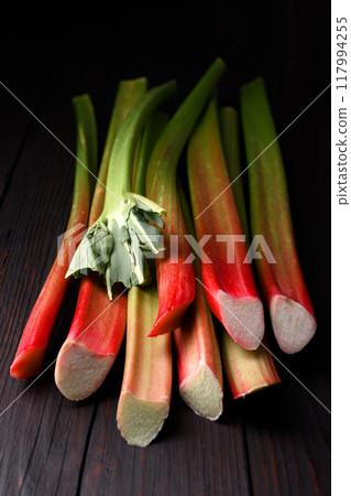 Ripe rhubarb stalks on a wooden table close up Ripe rhubarb stalks on a wooden table close up 117994255