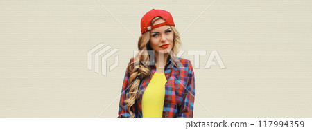 Stylish young blonde woman posing with skateboard on city street Stylish young blonde woman posing with skateboard on city street 117994359