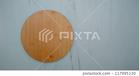round wooden plate on white kitchen table 117995130