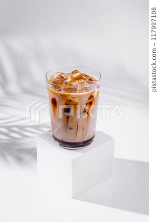 Iced coffee drink standing on white cube with chocolate syrup 117997108