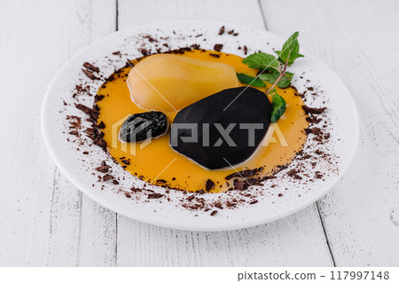 Pears poached in wine with chocolate sauce decorating modern gourmet restaurant dessert plate 117997148