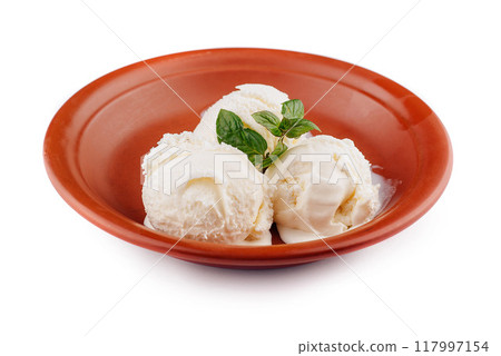 Three scoops of vanilla ice cream melting in rustic bowl with mint garnish 117997154