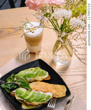 Blogger enjoying healthy breakfast with avocado toast and latte Blogger enjoying healthy breakfast with avocado toast and latte 117997218