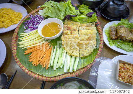 A table full of delicious Vietnamese Banh Xeo. A table full of delicious Vietnamese Banh Xeo. 117997242