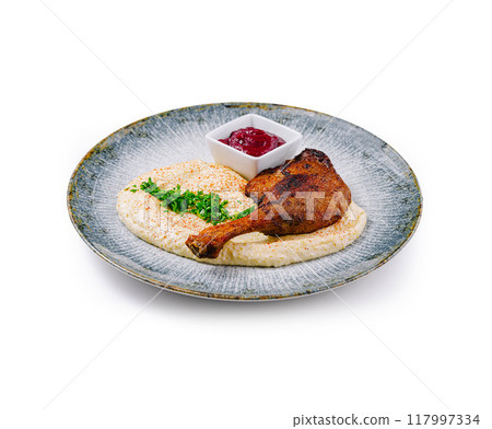 Roasted duck leg served on a plate with mashed potatoes and berry sauce Roasted duck leg served on a plate with mashed potatoes and berry sauce 117997334