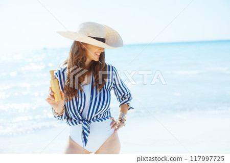 happy elegant female on seacoast with sunscreen 117997725