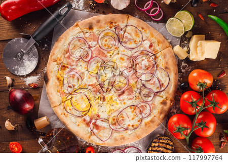 Delicious pizza lying on wooden table surrounded by fresh ingredients 117997764