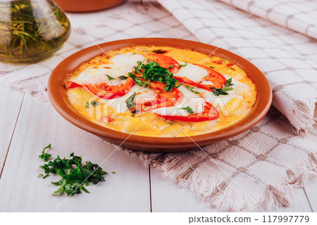 Delicious italian gnocchi with mozzarella and tomatoes being served on a white wooden table 117997779