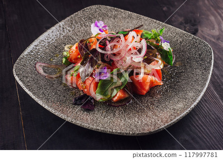 Fresh tomato salad with red onions and basil on gray plate 117997781