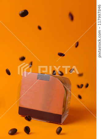 Coffee beans falling around coffee packaging on orange background Coffee beans falling around coffee packaging on orange background 117997846