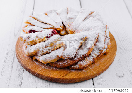 Delicious homemade cherry pie sprinkled with powdered sugar on white rustic table 117998062