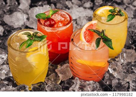 Four refreshing cocktails sitting on ice with mint garnish Four refreshing cocktails sitting on ice with mint garnish 117998182