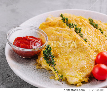 Cheesy omelette or chicken steak with cherry tomatoes and sauce Cheesy omelette or chicken steak with cherry tomatoes and sauce 117998408