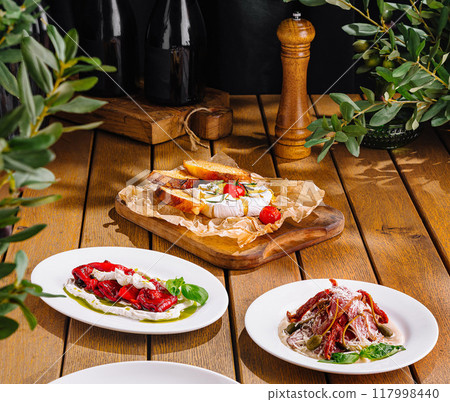 Variety of delicious bruschetta on rustic wooden table with wine and fresh ingredients 117998440