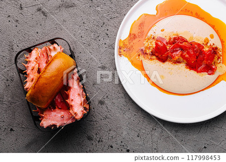 Gourmet hot dog with artisan toppings on dark surface 117998453