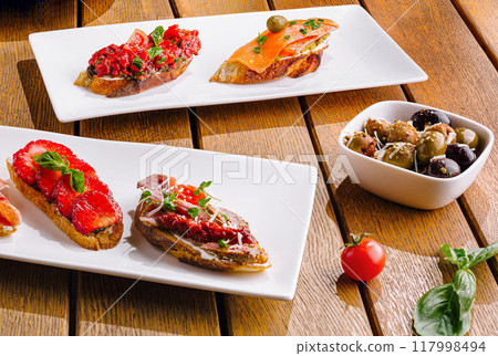 Gourmet bruschetta assortment on wooden table Gourmet bruschetta assortment on wooden table 117998494