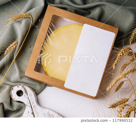 Artisan cheese wheel in craft packaging on rustic table Artisan cheese wheel in craft packaging on rustic table 117998532
