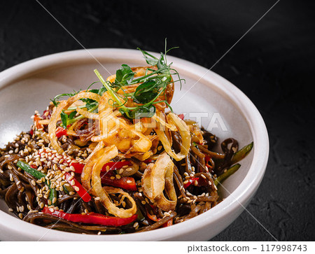 Exotic spicy noodle dish on dark background Exotic spicy noodle dish on dark background 117998743