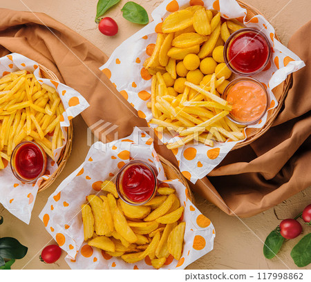 Assorted fried snacks with dipping sauces on table 117998862