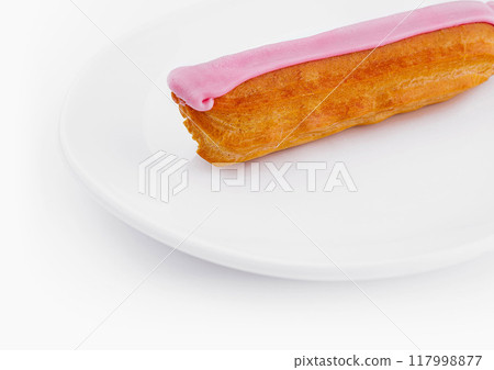 Pink frosted eclair on white plate Pink frosted eclair on white plate 117998877