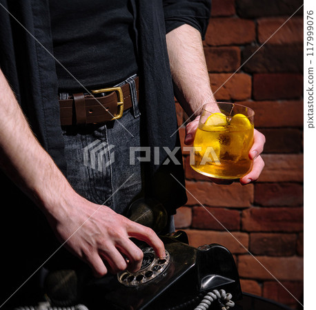 Mysterious man dialing a vintage telephone close up 117999076