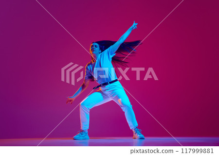 Artistic, energetic and expressive young woman in casual clothes in motion, dancing hip-hop against magenta, pink background in neon light Artistic, energetic and expressive young woman in casual clothes in motion, dancing hip-hop against magenta, pink background in neon light 117999881