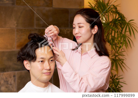 Female hair stylist cutting customer's hair, hair salon, beauty salon image 117999899