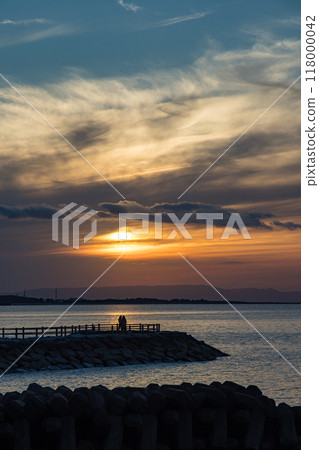 The coastline of Futaminoura, Ise City, Mie Prefecture, Japan, and the orange-hued sunset sky 118000042