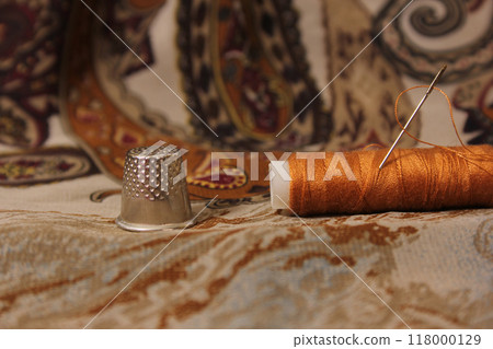 Brown Thread With Thimble and Scissors on Vintage Fabric Brown Thread With Thimble and Scissors on Vintage Fabric 118000129