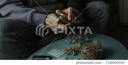shreds a cannabis bud with a grinder, banner format 118000391