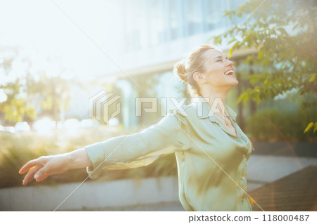 smiling modern woman employee near business center rejoicing smiling modern woman employee near business center rejoicing 118000487