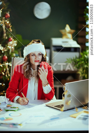 business woman in green office with Christmas tree working 118000683
