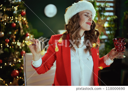 business woman in green office with Christmas tree dancing 118000690