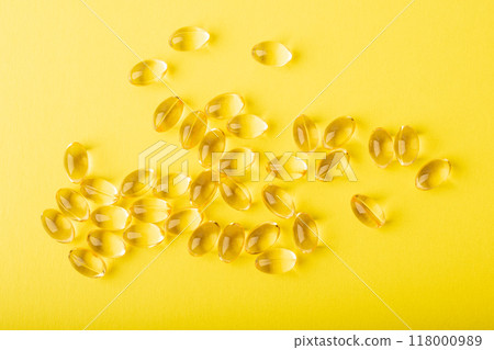Omega 3 fish oil top wiev. Vitamins in soft capsules on yellow background, cod liver oil. Concept of healthcare, supplements, vitamin D, treatment. Copy space, flatlay, banner. High quality photo Omega 3 fish oil top wiev. Vitamins in soft capsules on yellow background, cod liver oil. Concept of healthcare, supplements, vitamin D, treatment. Copy space, flatlay, banner. High quality photo 118000989