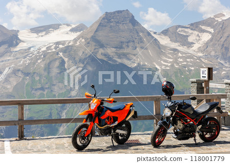 Scenic view of two parked motorcycles at Grossglockner High Alpine Road pass Tyrol Austria Alps mountain landscape background. Motorbike pair travel adventure journey trip lifestyle culture in Europe Scenic view of two parked motorcycles at Grossglockner High Alpine Road pass Tyrol Austria Alps mountain landscape background. Motorbike pair travel adventure journey trip lifestyle culture in Europe 118001779