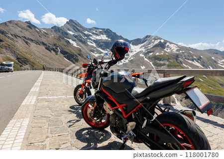 Scenic view of two parked motorcycles at Grossglockner High Alpine Road pass Tyrol Austria Alps mountain landscape background. Motorbike pair travel adventure journey trip lifestyle culture in Europe 118001780