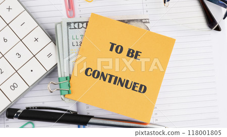 TO BE CONTINUED text written on a yellow sticker on top of dollar bills TO BE CONTINUED text written on a yellow sticker on top of dollar bills 118001805
