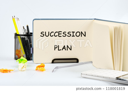 SUCCESSION PLAN word alphabet letters on a blank sheet of notepad in the stand 118001819