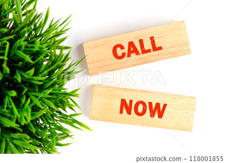 Conceptual call now symbol. Copy space. Call now message written it is laid out with wooden blocks on a white background, top view 118001855