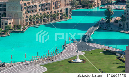 Top close up view of the bridge over man-made lake and some people walking in park 118003358