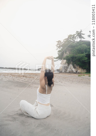 坐在海邊做瑜珈的年輕女子 坐在海邊做瑜珈的年輕女子 118003411
