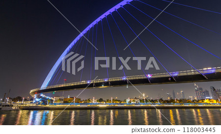 Futuristic Pedestrian Bridge over the Dubai Water Canal Illuminated at Night timelapse hyperlapse, UAE. Futuristic Pedestrian Bridge over the Dubai Water Canal Illuminated at Night timelapse hyperlapse, UAE. 118003445