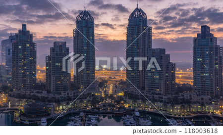 Aerial view of modern skyscrapers night to day timelapse before sunrise in Dubai Marina in Dubai, UAE. 118003618