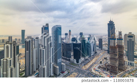 Dubai's business bay towers before sunset timelapse. Rooftop view of some skyscrapers and new towers under construction. 118003878