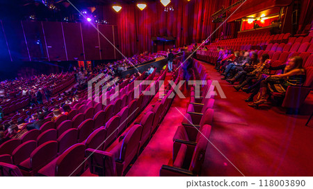 Spectators gather in the auditorium and watch the show in theatre timelapse. Large hall with red armchairs seats Spectators gather in the auditorium and watch the show in theatre timelapse. Large hall with red armchairs seats 118003890